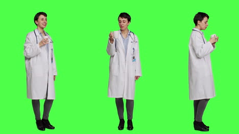 Woman-physician-drinking-a-cup-of-coffee-against-greenscreen-backdrop